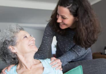 Female family caregiver reaching to embrace senior love done.