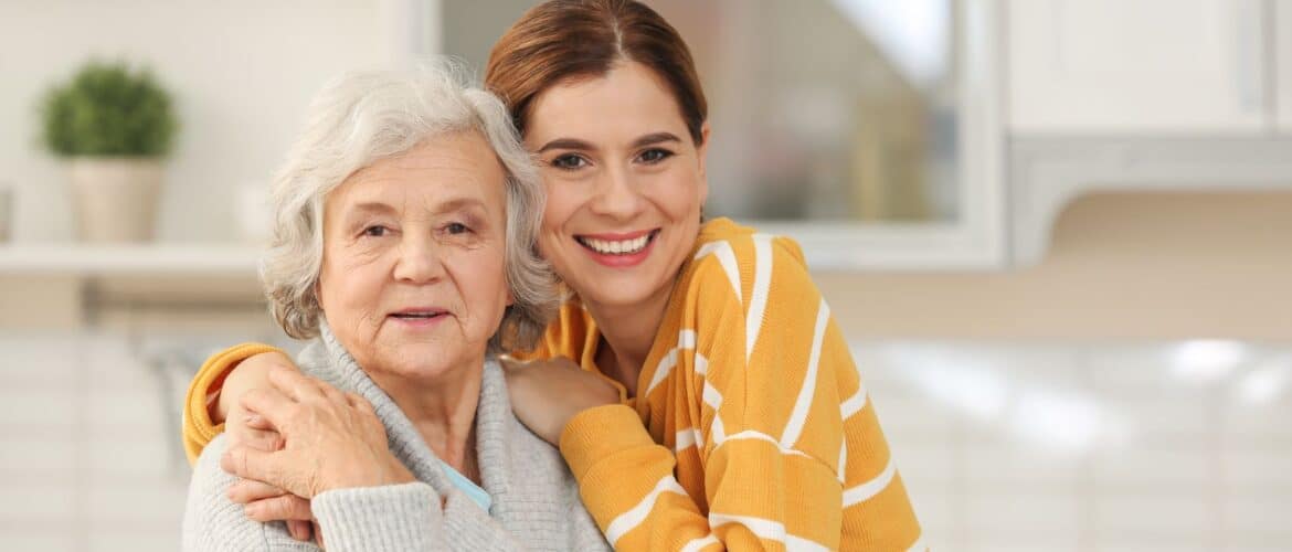 Senior female pictured hugging female caregiver or relative